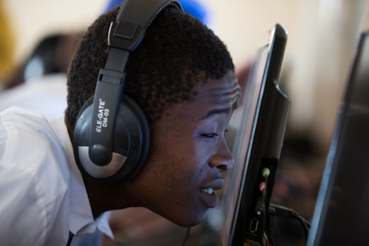 A boy with low vision using a desktop computer