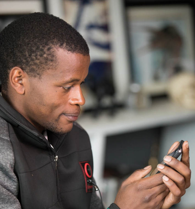 Dominic Gicheha using smartphone
