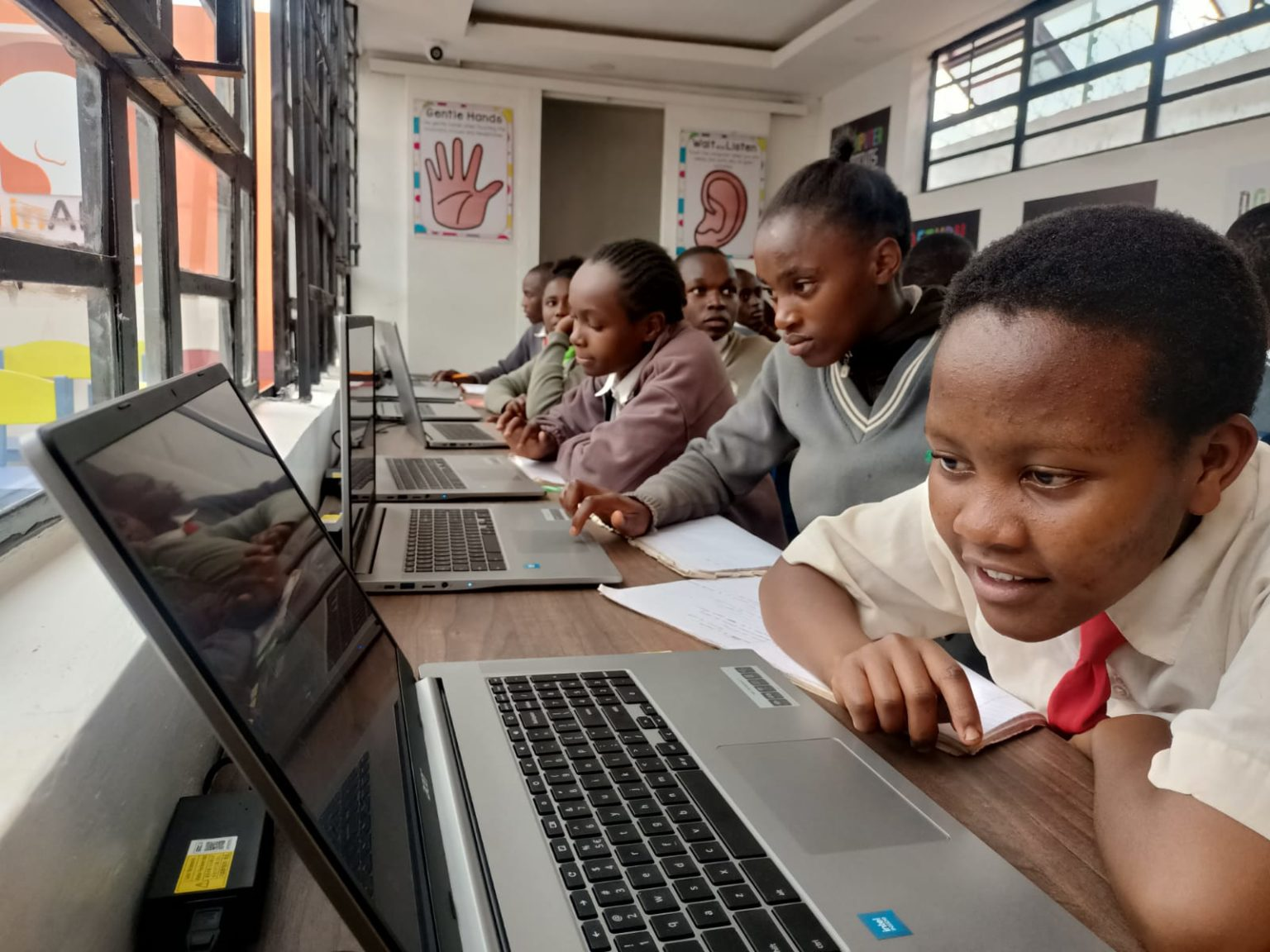 Students are working on laptops st Kang’aru Digital Hub. The environment appears to be a modern and well-equipped computer lab.